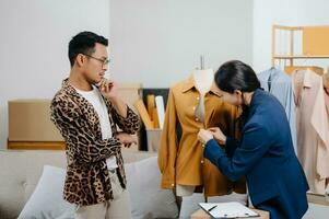 Diverse female fashion designers at work with tailor centimeters on necks and holds tablet and smartphone. independent creative design business. photo