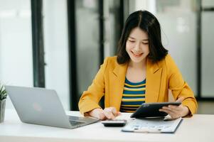 Woman freelancer is working her job on computer tablet and laptop Doing accounting analysis report real estate investment data, Financial at modern office photo