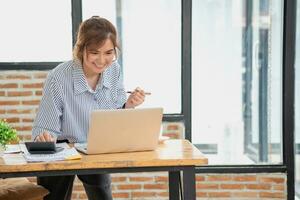 Beautiful young teen Asian business woman using computer laptop with hands up in winner is a gesture, Happy to be successfully celebrating achievement success. photo