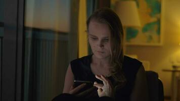 Frau mit ein Smartphone im gemütlich Abend Innere video