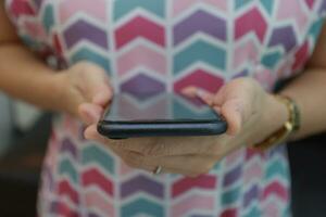 Mobile phone in hand, hand using mobile phone in home photo