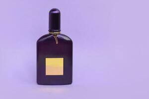 Tom Ford velvet orchid fragrance perfume bottle lies on light lilac background. Tom Ford is American fashion designer launched his eponymous luxury brand in 2006 photo