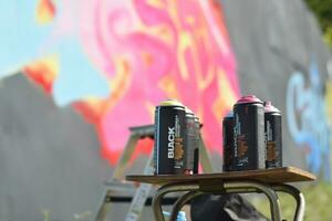 Used Montana black and hardcore aerosol spray cans against graffiti paintings. MTN or Montana-cans is manufacturer of high pressure spray paint goods photo