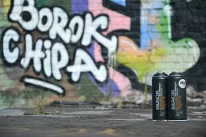 Used Montana black aerosol spray cans against graffiti paintings. MTN or Montana-cans is manufacturer of high pressure spray paint goods photo