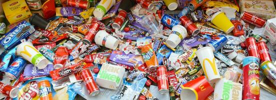 Many wrappings and cans from used products by famous worldwide brands. Pattern of trash of various colors and materials photo