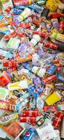 Many wrappings and cans from used products by famous worldwide brands. Pattern of trash of various colors and materials photo