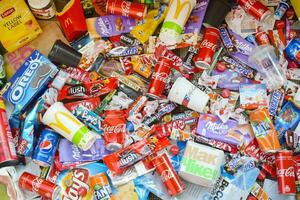 Many wrappings and cans from used products by famous worldwide brands. Pattern of trash of various colors and materials photo