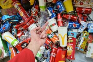 Many wrappings and cans from used products by famous worldwide brands. Pattern of trash of various colors and materials photo