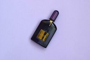 Tom Ford velvet orchid fragrance perfume bottle lies on light lilac background. Tom Ford is American fashion designer launched his eponymous luxury brand in 2006 photo