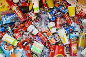 Many wrappings and cans from used products by famous worldwide brands. Pattern of trash of various colors and materials photo