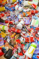 Many wrappings and cans from used products by famous worldwide brands. Pattern of trash of various colors and materials photo
