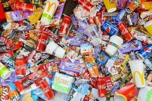 Many wrappings and cans from used products by famous worldwide brands. Pattern of trash of various colors and materials photo