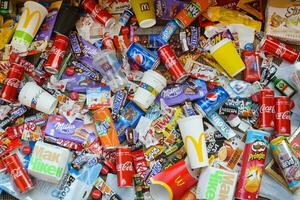 Many wrappings and cans from used products by famous worldwide brands. Pattern of trash of various colors and materials photo