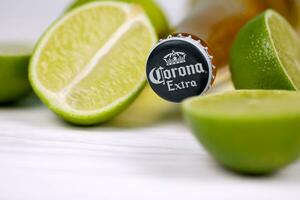 KHARKOV, UKRAINE - DECEMBER 9, 2020 Bottle of Corona Extra Beer with lime slices. Corona produced by Grupo Modelo with Anheuser Busch InBev most popular imported beer in the US photo