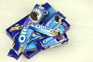 KHARKOV, UKRAINE - DECEMBER 8, 2020 Oreo sandwich cookies and blue product boxes on white table. Oreo is a sandwich cookie with a sweet cream is the best selling cookie in US photo