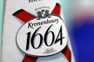 KHARKOV, UKRAINE - DECEMBER 8, 2020 Blanc logo on beer bottles on white table. 1664 Blanc is the wheat beer from French brewery Kronenbourg exported worldwide photo