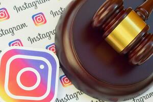 Instagram paper logo lies with wooden judge gavel. Entertainment lawsuit concept photo