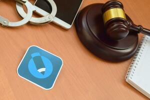 Livejournal paper logo lies with wooden judge gavel, smartphone and handcuffs. Entertainment lawsuit concept photo