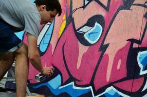 kharkov, ucrania - 27 de mayo de 2017 festival de artes callejeras. jóvenes dibujan graffiti en paredes portátiles de madera en el centro de la ciudad. el proceso de pintar en las paredes con latas de aerosol foto