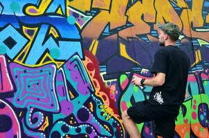 KHARKOV, UKRAINE - MAY 27, 2017 Festival of street arts. Young guys draw graffiti on portable wooden walls in the center of the city. The process of painting on walls with aerosol spray cans photo