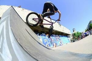 kharkiv, ucrania - 27 de mayo de 2018 ciclistas de bmx freestyle en un skatepark durante el festival anual de culturas callejeras foto