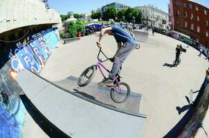 kharkiv, ucrania - 27 de mayo de 2018 ciclistas de bmx freestyle en un skatepark durante el festival anual de culturas callejeras foto