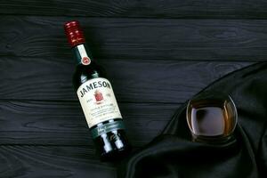 KHARKOV, UKRAINE - DECEMBER 3, 2020 Jameson triple distilled irish whiskey bottle on dark black background. Elite alcohol photo
