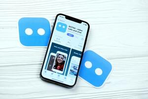 KHARKOV, UKRAINE - MARCH 5, 2021 Botim messenger icon and application from App store on iPhone 12 pro display screen on white table photo