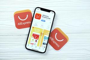 KHARKOV, UKRAINE - MARCH 5, 2021 Aliexpress icon and application from App store on iPhone 12 pro display screen on white table photo