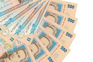 200 billetes de hryvnias ucranianos se encuentran aislados en fondo blanco con espacio de copia apilados en forma de abanico de cerca foto