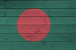 Bangladesh flag depicted in bright paint colors on old wooden wall. Textured banner on rough background photo