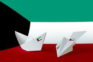 Kuwait flag depicted on paper origami airplane and boat. Handmade arts concept photo