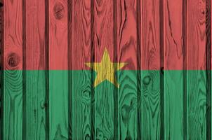 Burkina Faso flag depicted in bright paint colors on old wooden wall. Textured banner on rough background photo