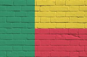 Benin flag depicted in paint colors on old brick wall. Textured banner on big brick wall masonry background photo