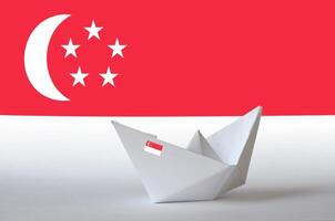 Singapore flag depicted on paper origami ship closeup. Handmade arts concept photo