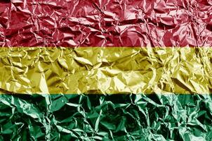 Bolivia flag depicted in paint colors on shiny crumpled aluminium foil closeup. Textured banner on rough background photo