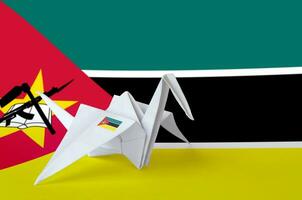 Mozambique flag depicted on paper origami crane wing. Handmade arts concept photo