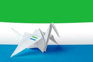 Sierra Leone flag depicted on paper origami crane wing. Handmade arts concept photo