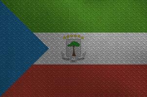 Equatorial Guinea flag depicted in paint colors on old brushed metal plate or wall closeup. Textured banner on rough background photo