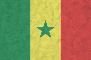 Senegal flag depicted in bright paint colors on old relief plastering wall. Textured banner on rough background photo