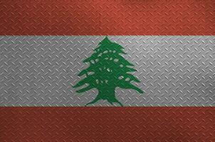 Lebanon flag depicted in paint colors on old brushed metal plate or wall closeup. Textured banner on rough background photo