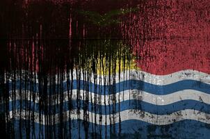 Kiribati flag depicted in paint colors on old and dirty oil barrel wall closeup. Textured banner on rough background photo