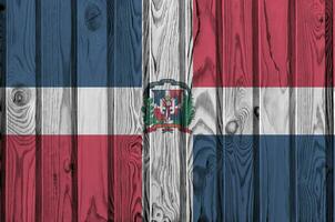 Dominican Republic flag depicted in bright paint colors on old wooden wall. Textured banner on rough background photo