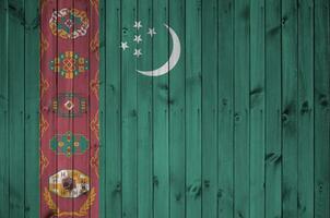 bandera de turkmenistán representada en colores de pintura brillante en una pared de madera vieja. banner texturizado sobre fondo áspero foto