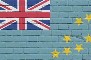 Tuvalu flag depicted in paint colors on old brick wall. Textured banner on big brick wall masonry background photo