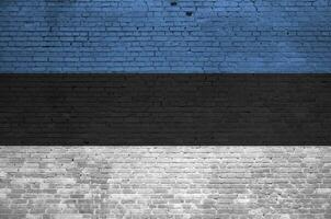 Estonia bandera representado en pintar colores en antiguo ladrillo pared. texturizado bandera en grande ladrillo pared albañilería antecedentes foto