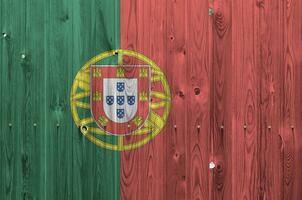 Portugal flag depicted in bright paint colors on old wooden wall. Textured banner on rough background photo