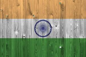 India flag depicted in bright paint colors on old wooden wall. Textured banner on rough background photo