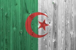 bandera de argelia representada en colores de pintura brillante en una pared de madera vieja. banner texturizado sobre fondo áspero foto