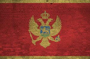 montenegro bandera representado en pintar colores en antiguo ladrillo pared. texturizado bandera en grande ladrillo pared albañilería antecedentes foto